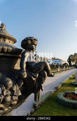 Sculpture noire d'un enfant avec le doigt sur les lèvres gestuant pour le silence situé dans le beau jardin Bahai à Bahji, Israël Banque D'Images