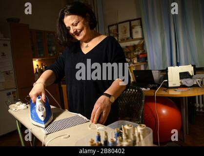 Prague, République tchèque. 18 mars 2020. Zuzana Kopeckova fabrique des masques avec un tissu à la maison à Prague, en République tchèque, le 18 mars 2020. En raison de la propagation rapide de COVID-19, la République tchèque est aujourd'hui confrontée à une pénurie d'équipements médicaux comme les masques. Zuzana travaille à une chaîne de télévision locale, mais elle travaille maintenant à la maison en raison de l'épidémie. Elle fait volontairement des masques pour les collègues et les amis à son temps libre. Crédit: Dana Kesnerova/Xinhua/Alay Live News Banque D'Images