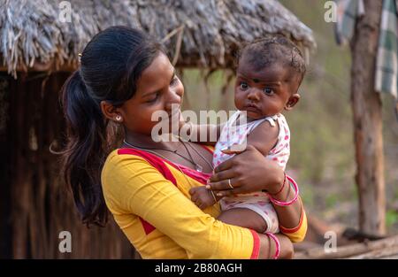 Odisha/Inde - 13 mars 2020. Une jeune fille non identifiée tenant son frère bébé et souriant. Banque D'Images