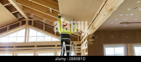 Travailleur de la construction écologique isolant thermique maison à ossature en bois Banque D'Images