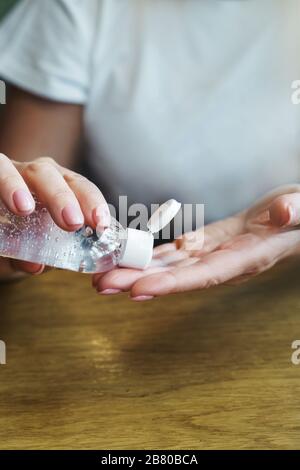 Une femme dans un café traite ses mains avec un antiseptique désinfectant Banque D'Images