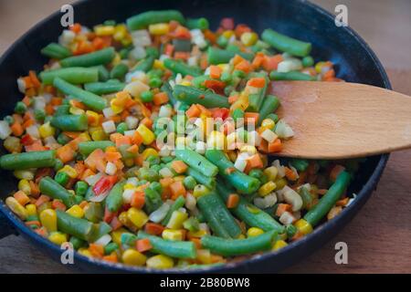 Un mélange coloré de légumes est frit dans une poêle à frire près. Nourriture Banque D'Images