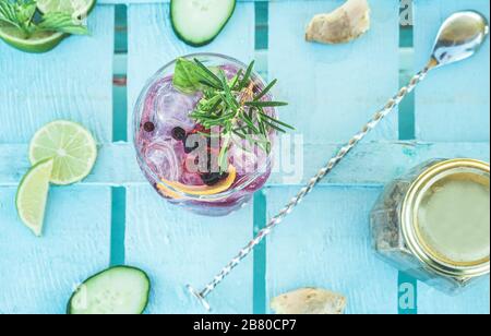 Vue de dessus du cocktail de mojito de baies sur le comptoir de bar en bois bleu - tropical, boissons, fête et concept - se concentrer sur le verre Banque D'Images