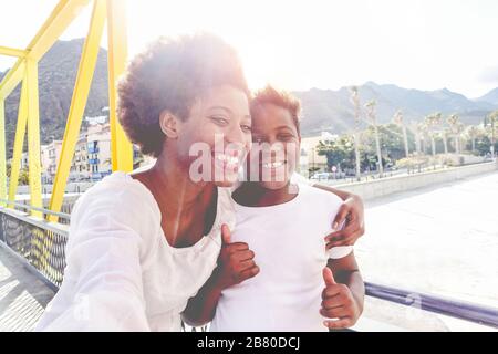 Bonne jeune mère s'amuser avec son enfant en été ensoleillé jour - son embrassant sa mère en plein air avec soleil arrière lumière - style de vie de famille, maternité, lov Banque D'Images