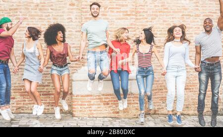 Joyeux millénaires amis sautant en plein air - jeunes ayant l'amusement ensemble - style de vie des jeunes, équipe, multiracial, concept d'amitié - l'accent principal sur Banque D'Images