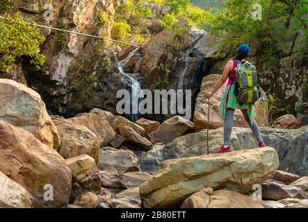 Un Voyageur seul indien qui bénéficie de la vue d'un Waterfall portant son sac à dos. Banque D'Images
