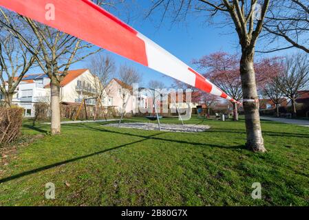 Rot-weisses Absperrband an einem gesperrten Kinderspielplatz während der Corona-KRise in Deutschland Banque D'Images