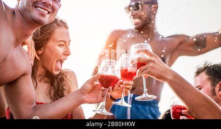 Joyeux amis à boire du vin sangria lors d'une soirée bateau exclusive - jeunes gens qui s'amusent en vacances d'été - Focus sur le verre de main d'homme gauche - Voyage, frie Banque D'Images