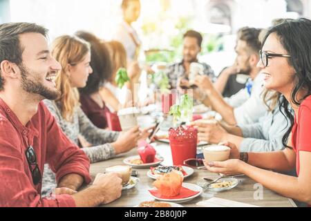 Des amis heureux ayant une pause-café au bar cafétéria - des étudiants qui apprécient le petit déjeuner ensemble - concept d'amitié et de bonne humeur - Focus sur la bonne femme - Banque D'Images