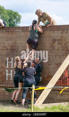 Difficile obstacle au Mudder course: Les participants s'attaquent à l'obstacle du mur de Berlin Banque D'Images