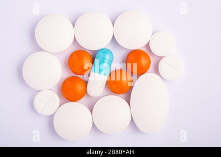 Pilules et comprimés sur fond blanc vif, concept médical de santé, antibiotiques et cure, vue de dessus Banque D'Images