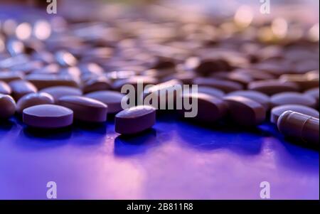 Pilules blanches, comprimés capsule sur fond bleu. Couleur du concept de l'année Banque D'Images