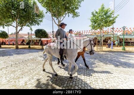 Cavaliers à cheval vêtus de costumes traditionnels à la foire d'avril (Feria de Abril), la foire de Séville (Feria de Sevilla Banque D'Images