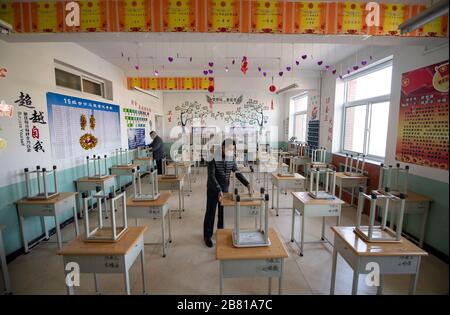 Taiyuan, la province chinoise de Shanxi. 19 mars 2020. Le personnel organise des tables et des chaises dans une salle de classe d'une école à Taiyuan, capitale de la province de Shanxi en Chine du nord, le 19 mars 2020. Les élèves des troisième classes des écoles secondaires de la province de Shanxi commenceront leur nouveau semestre le 25 mars, les écoles préparant pleinement leur nouveau mandat. Crédit: Yang Chenguang/Xinhua/Alay Live News Banque D'Images