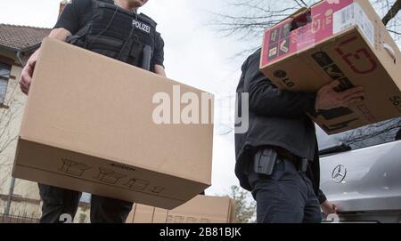 Berlin, Allemagne. 19 mars 2020. Des policiers transportant des boîtes d'une maison après un raid d'appartement. Après l'interdiction du groupe Reich Citizens 'United German Peoples and Tribes', des raids ont eu lieu dans plusieurs États fédéraux. Crédit: Carsten Koall/dpa/Alay Live News Banque D'Images