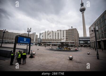 Berlin, Allemagne. 19 mars 2020. Les gardes de sécurité du Berliner Verkehrsbetriebe (BVG) se trouvent à l'entrée de la station de métro Alexanderplatz. En raison de la crise de la couronne, l'Alexanderplatz centrale, à l'est de la capitale, est en grande partie désertée. Crédit: Michael Kappeler/dpa/Alay Live News Banque D'Images