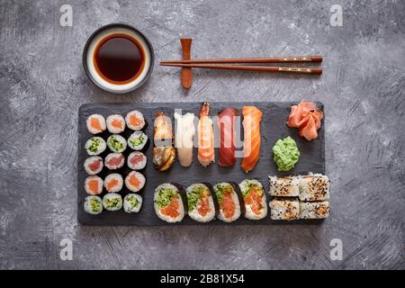 Composition de différents types de rouleaux de sushi sur pierre noire board Banque D'Images