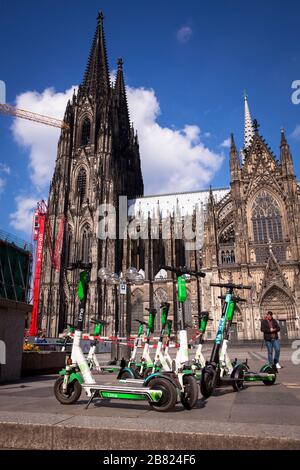 Scooters électriques à louer en face de la cathédrale, Cologne, Allemagne. Lime-S Elektroscooter zum mieten vor dem Dom, Koeln, Deutschland. Banque D'Images