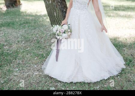 Mariée est titulaire d'un bouquet de mariage, robe de mariage, mariage de détails Banque D'Images