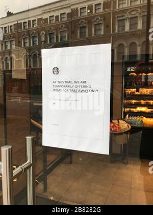Un avis dans la fenêtre d'un café Starbucks à Londres indique aux clients qu'il est en service à emporter uniquement. NHS Angleterre a annoncé que le nombre de morts de coronavirus avait atteint 137 au Royaume-Uni. Banque D'Images
