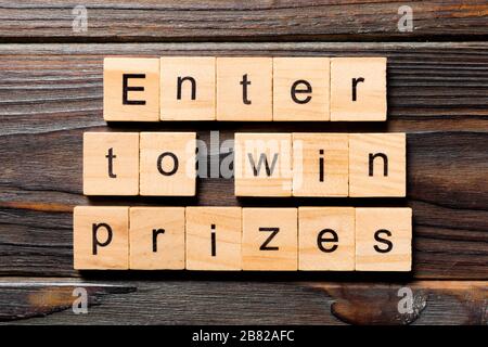 Entrez pour gagner des prix écrits sur le bloc de bois. Entrez pour gagner le texte des prix sur la table en bois pour votre concept de desing, Top View. Banque D'Images