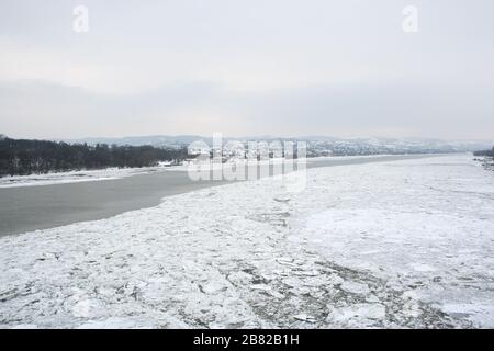 Glace brisée dans le Danube gelé à Novi Sad, Serbie avec Fruska gora dans le dos recouvert de neige. Banque D'Images