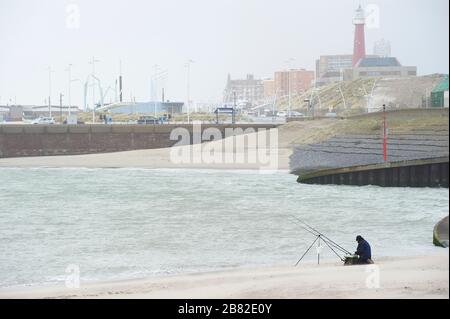 La Haye, Pays-Bas-Hollande-Sud - 200222: Pêcheur de pêche en mer sur une plage près du port de Scheveningen. Banque D'Images