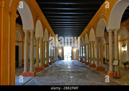 Un couloir avec des arches dans le bâtiment Alcazar de Séville Banque D'Images