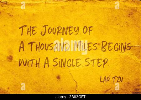 Le voyage de mille miles commence par une seule étape - ancienne citation du philosophe chinois Lao Tzu imprimée sur du papier jaune grunge Banque D'Images