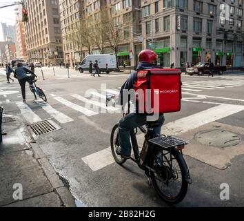 Un liveur avec un tote de marque DoorDash sur sa bicyclette dans le quartier de Chelsea à New York le vendredi 13 mars 2020. (© Richard B. Levine) Banque D'Images