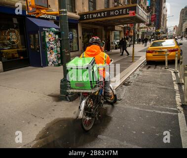 Un livreur de Relais attend sa prochaine commande de prise en charge à New York le mardi 17 mars 2020. En raison des besoins des bars et restaurants de distanciation sociale se ferment avec les restaurants autorisés à faire le départ et la livraison seulement. (© Richard B. Levine) Banque D'Images