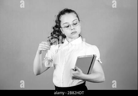 Les mesures de sécurité. Petit enfant de l'étude. Leçon de chimie. L'expérience éducative. Relations sérieuses in chimie. Jour des connaissances. Lycéenne avec des liquides chimiques. S'amuser avec la chimie. Concept de l'éducation. Banque D'Images