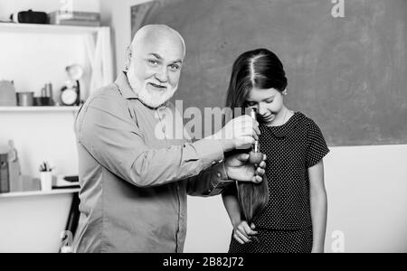 recherche en laboratoire. Analyse et synthèse. Élargir la connaissance du monde. Échantillon biologique. Enseignant mûr regarder dans la loupe tube sur la chaux. Petite fille explorer la tranche de fruits. École. Microscopie. Banque D'Images