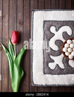 La nourriture nationale kazakh et kirghize kurt des boules salées blanches de fromage sec sur le korpeschka traditionnel feutre avec ornement près de tulipe rouge pendant le festinel de Nauryz Banque D'Images