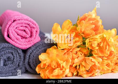 serviettes en rouleaux avec un bouquet de tulipes jaunes, le concept d'ouverture d'un nouveau spa ou salon de traitement Banque D'Images