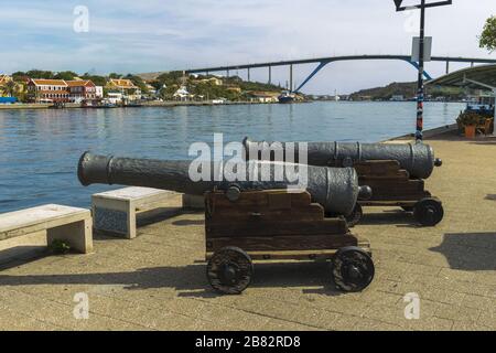 Vue rapprochée des vieilles canons d'artillerie médiévaux sur le paysage naturel. Magnifique pont Queen Juliana en face de la baie St. Anna à Willemstad. Banque D'Images