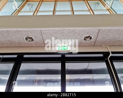 Vue rapprochée du mur blanc vert et du plafonnier, éclairage de sortie d'urgence. Banque D'Images