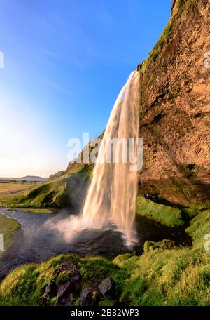 Magnifique chute d'eau Seljalandsfoss pendant l'heure d'or - format portrait, Sudurland, Islande Banque D'Images