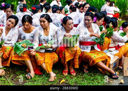 Un groupe de femmes dans le costume traditionnel manger déjeuner pendant UN festival hindou, Tirta Empul Water Temple, Bali, Indonésie. Banque D'Images