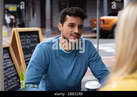 Couple caucasien dans la ville assis sur une terrasse de café Banque D'Images