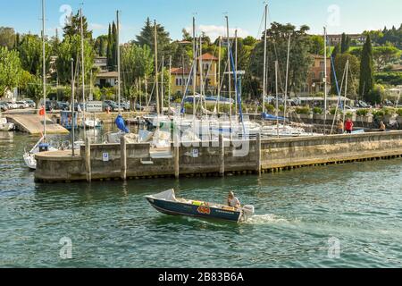 PORTESE, LAC DE GARDE, ITALIE - SEPTEMBRE 2018 : petit bateau à moteur extérieur sur le point d'entrer dans le port de Portese sur le lac de Garde. Banque D'Images