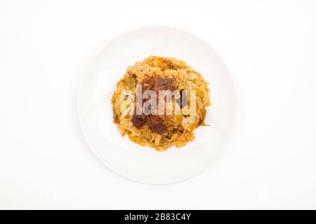 Porc aux poireaux et au riz. Vue de dessus mise au point sélective arrière-plan blanc. Banque D'Images