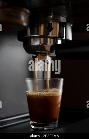 Gros plan d'une machine à café qui verse du café dans des tasses Banque D'Images