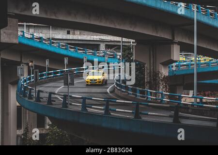 Chongqing, Chine - 20 décembre 2019 : taxi jaune sur le pont de pont de pont de survol en un jour pluvieux Banque D'Images