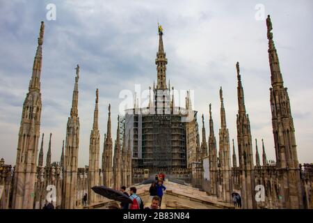 Les touristes peuvent visiter et profiter de la vue entourée par les flèches et les statues sur le toit de la cathédrale de Milan le printemps pluvieux, Italie, mai 2017 Banque D'Images