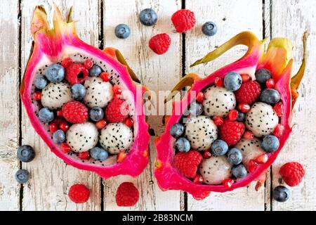 Salades colorées de fruits de dragon avec framboises et bleuets sur un fond de bois blanc Banque D'Images