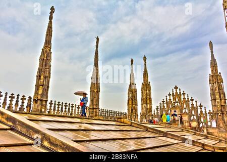 Les touristes peuvent visiter et profiter de la vue entourée par les flèches et les statues sur le toit de la cathédrale de Milan le printemps pluvieux, Italie, mai 2017 Banque D'Images