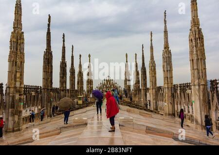 Les touristes peuvent visiter et profiter de la vue entourée par les flèches et les statues sur le toit de la cathédrale de Milan le printemps pluvieux, Italie, mai 2017 Banque D'Images