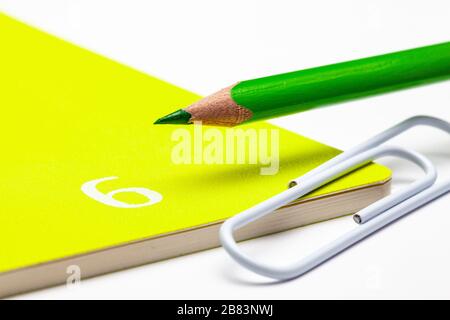 Organisateur pour le mois de juin, crayon vert et trombone blanc sur la table blanche. Banque D'Images