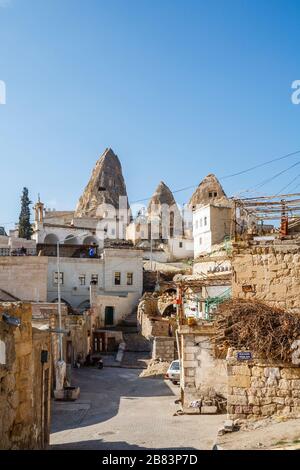 Vue sur une scène de rue dans le quartier historique de Göreme à côté d'une demeure troglodyte disutilisée, Cappadocia, Turquie Banque D'Images